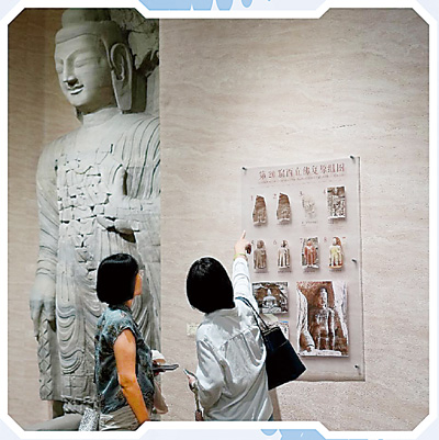 游客在3D打印的云冈石窟第20窟西立佛复原像前游览。新华社记者 刘颖摄